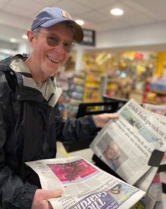 Tommy Shea going through newspapers in supermarket