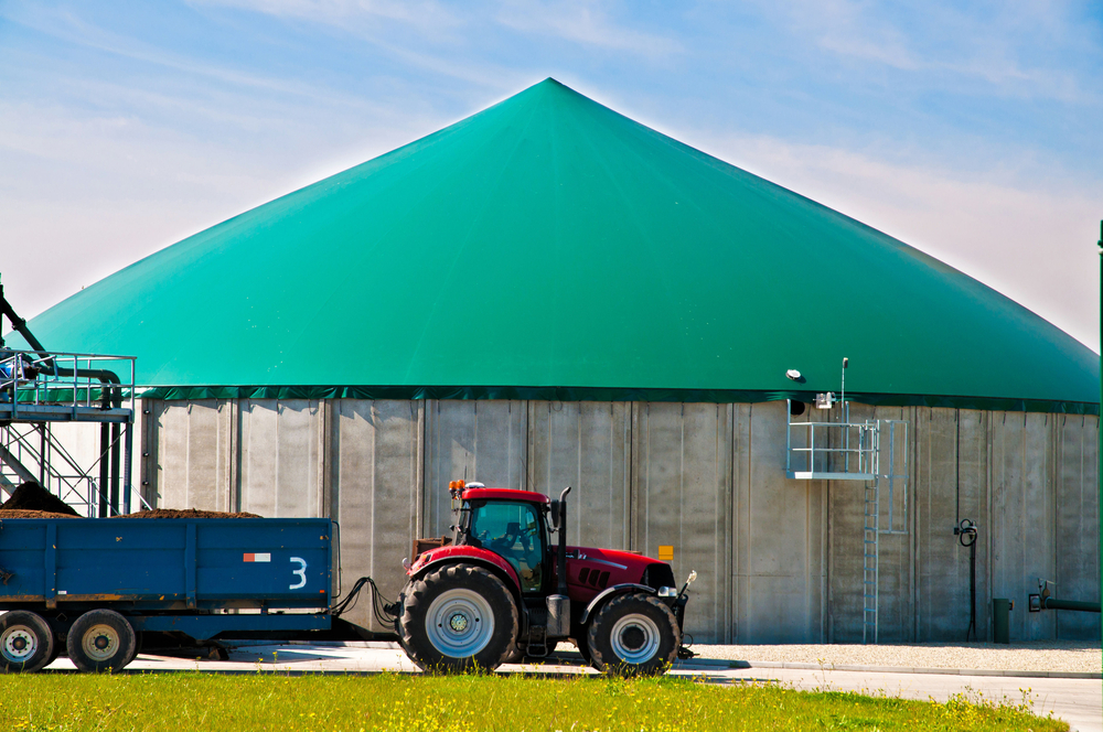 Red tractor in front of biogas plant